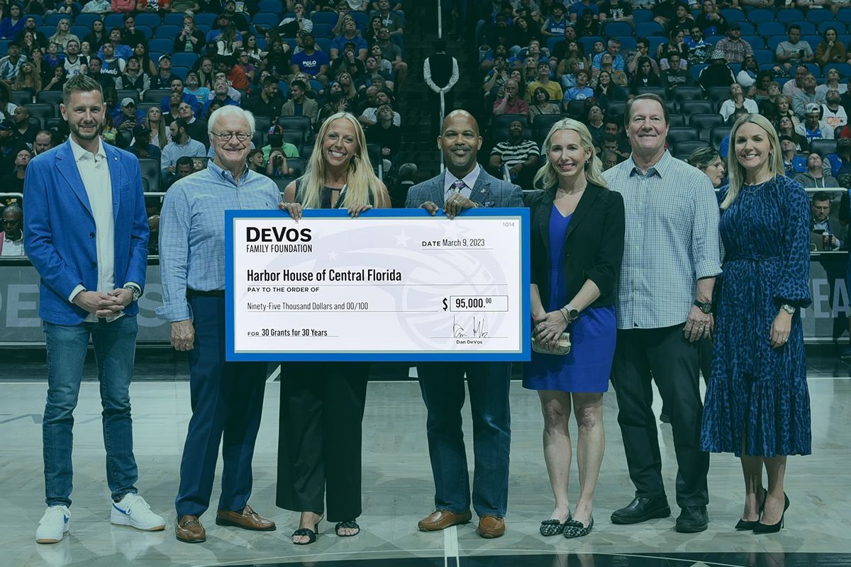 A group of people standing next to each other holding a large check.