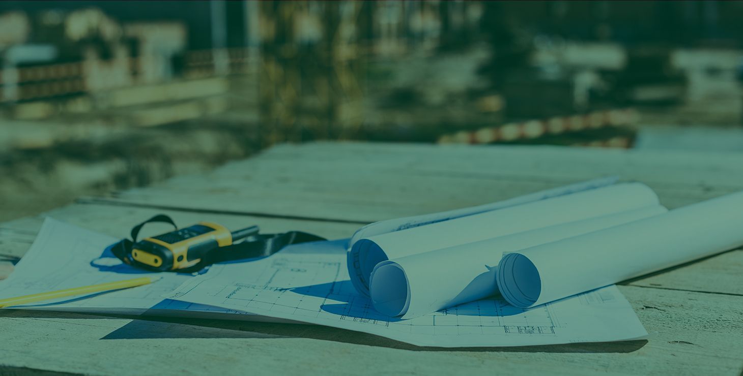 A construction site with blueprints and tools on the ground.