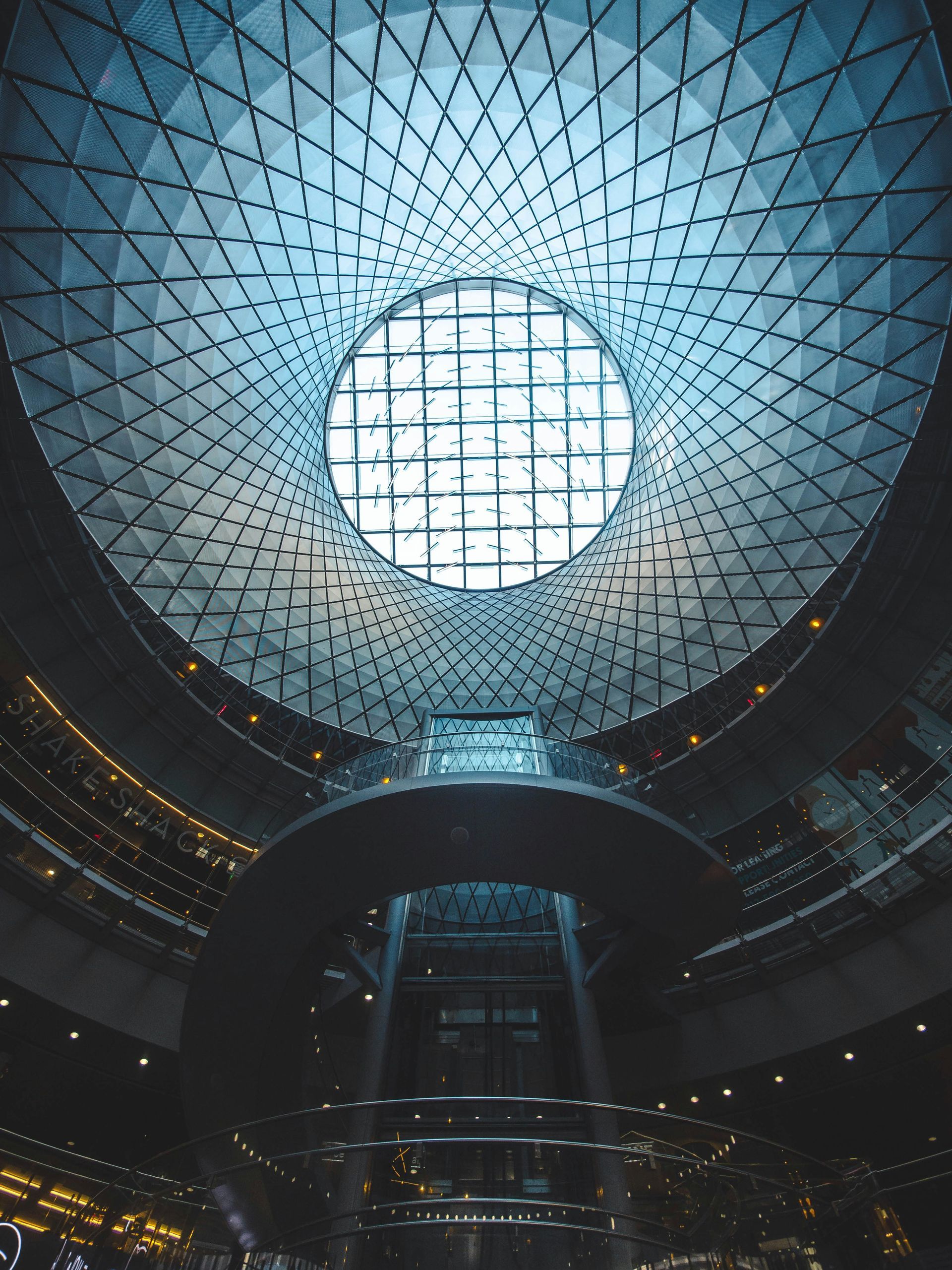 Looking up at the ceiling of a building with a circular window.