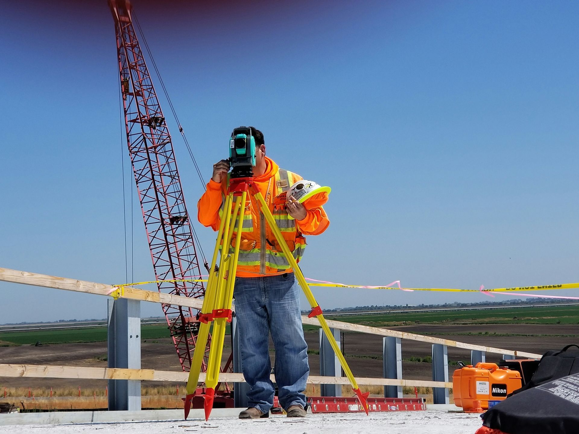 A construction worker is taking a picture with a camera