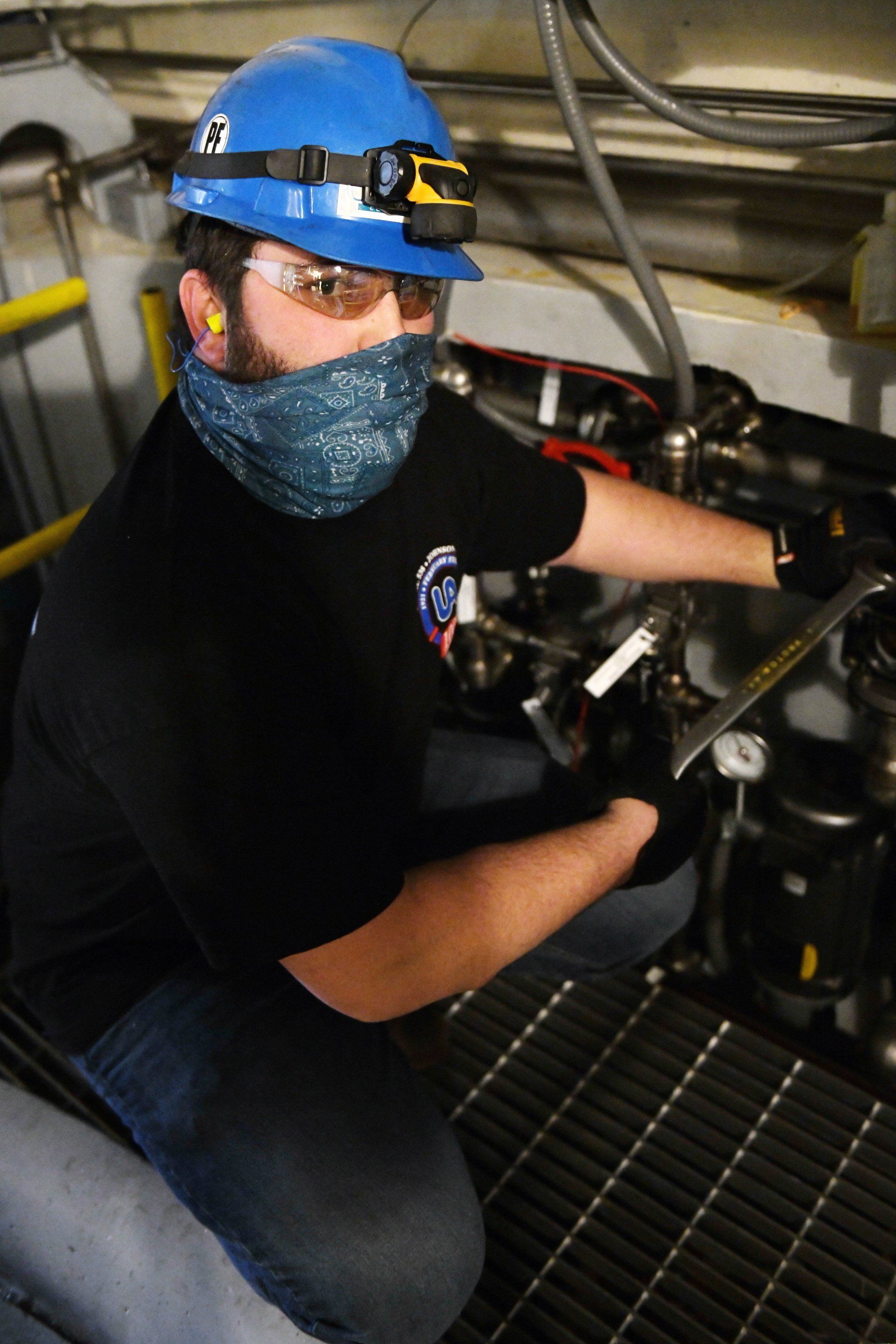 Local 538 Apprentice working on pipes in a lower locatoin