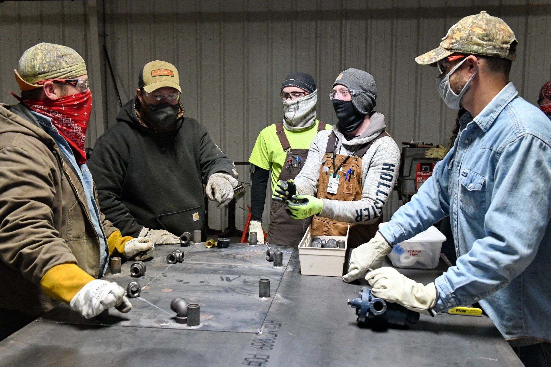 Local 538 apprentices standing around a mentor to learn about welding