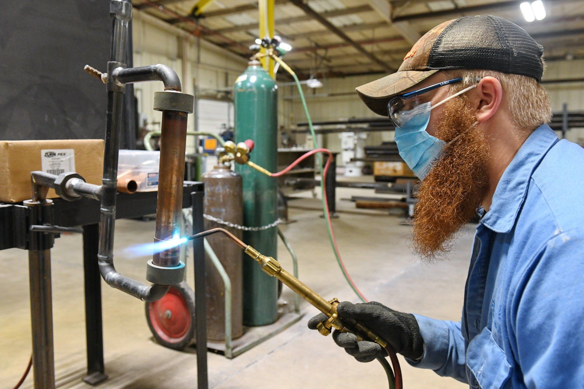 Local 538 apprentice using an oxy-acetylene rig to cut a pipe
