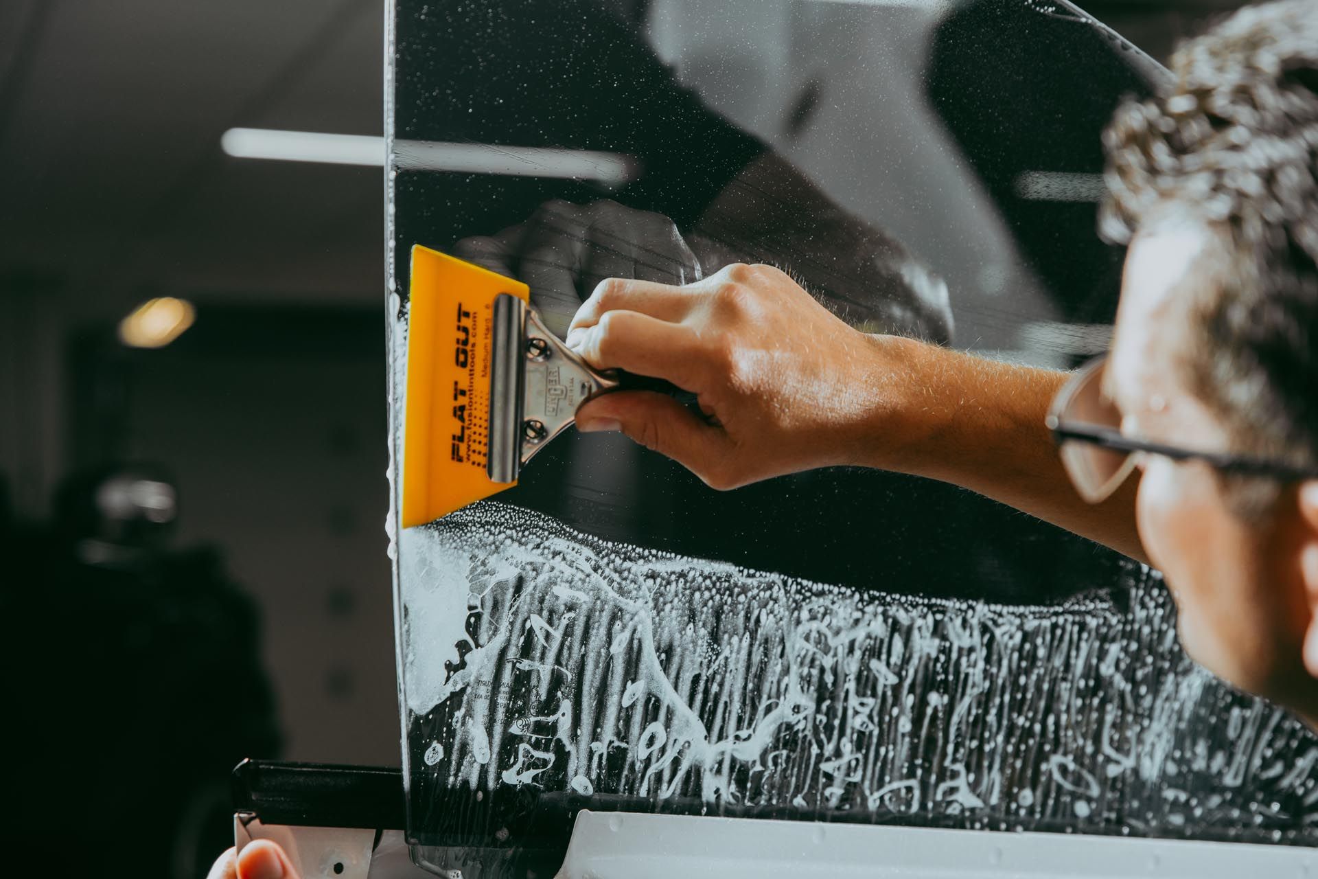 A person is cleaning a window with a squeegee.