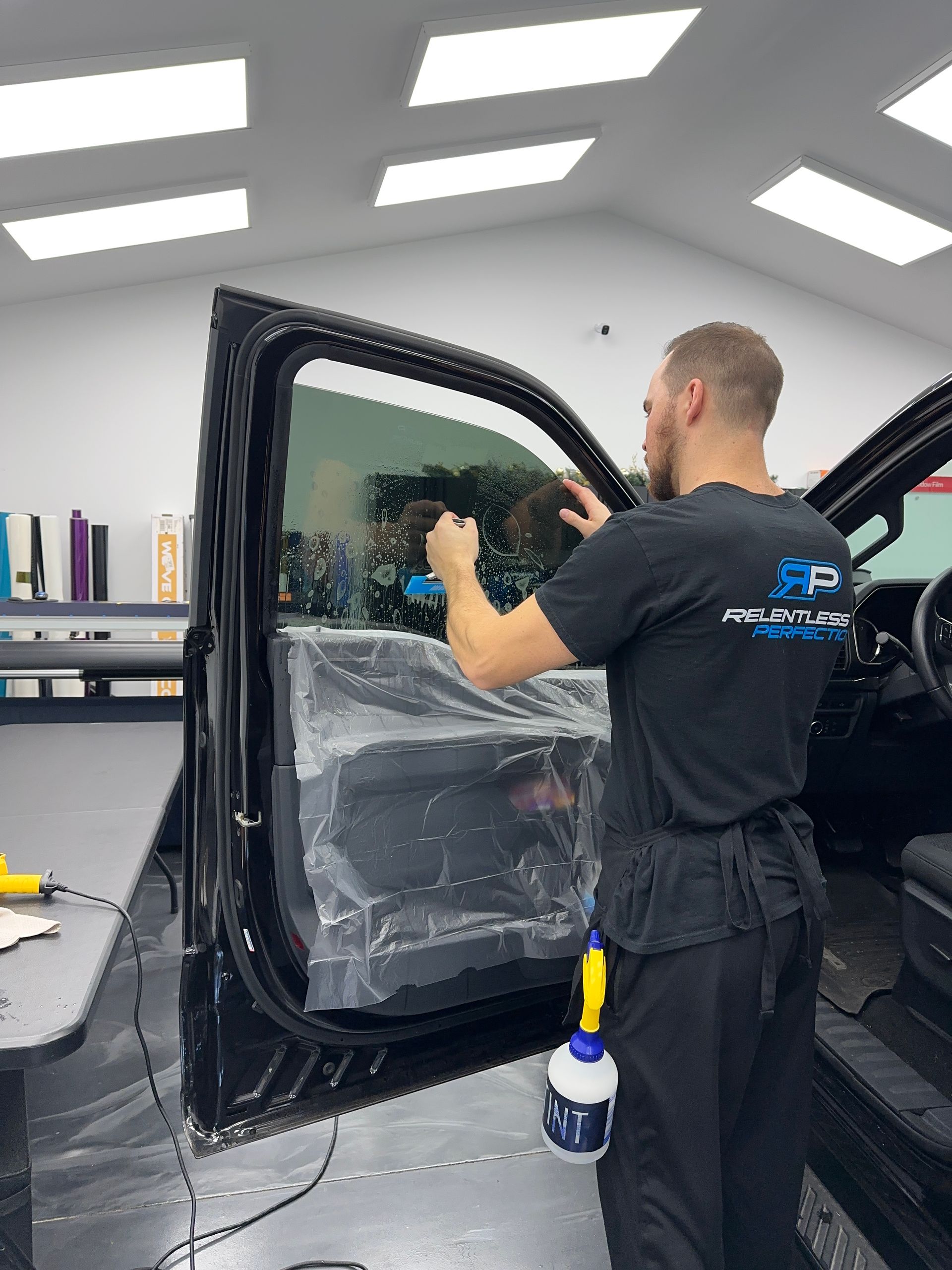 A person is installing a rear view mirror on a car.