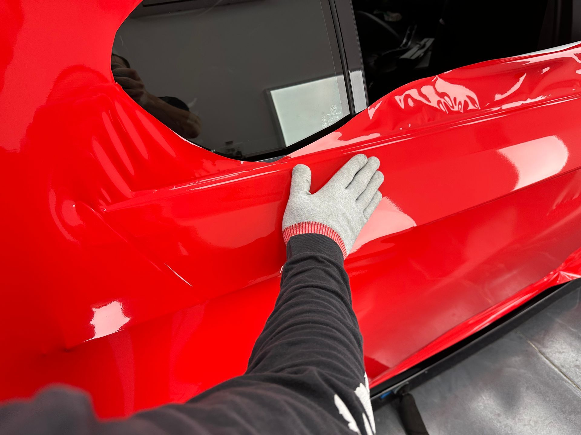 A man is wrapping a blue car with a blue wrap.