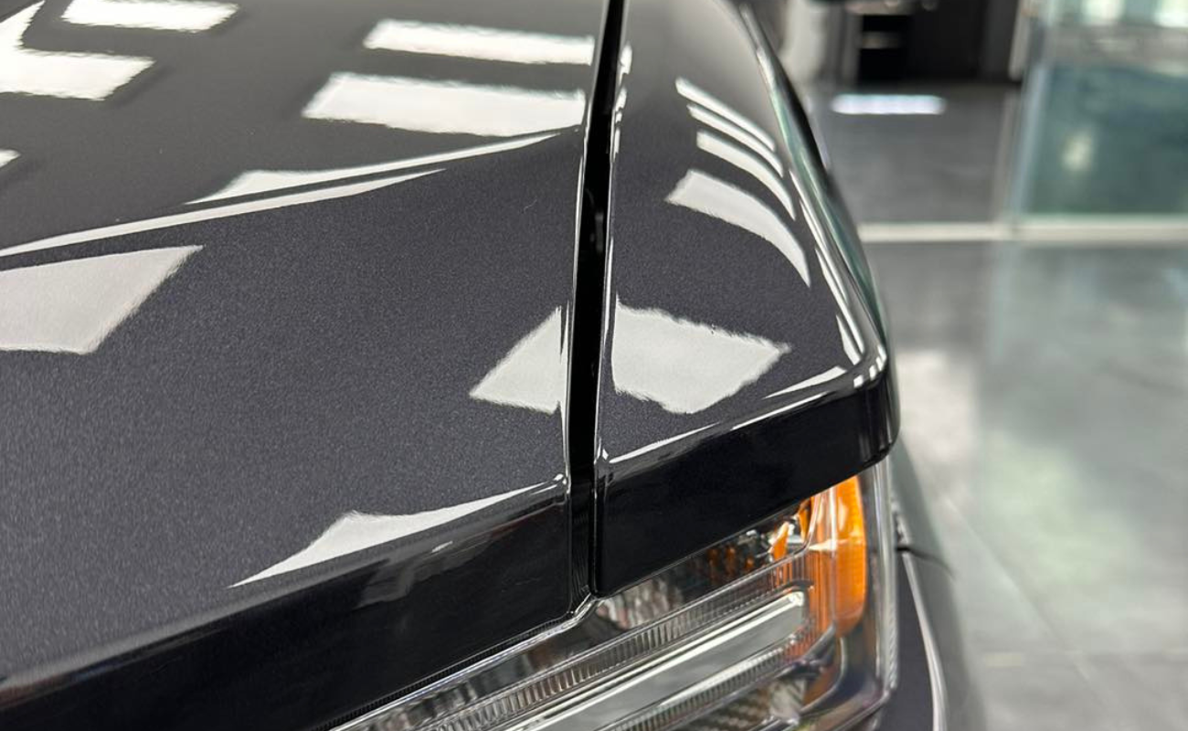 A close up of a car 's hood and headlight.