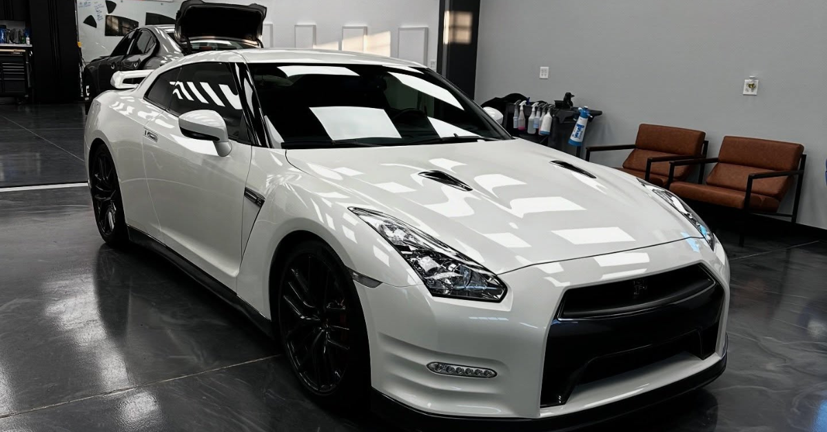 A white nissan gt r is parked in a garage.