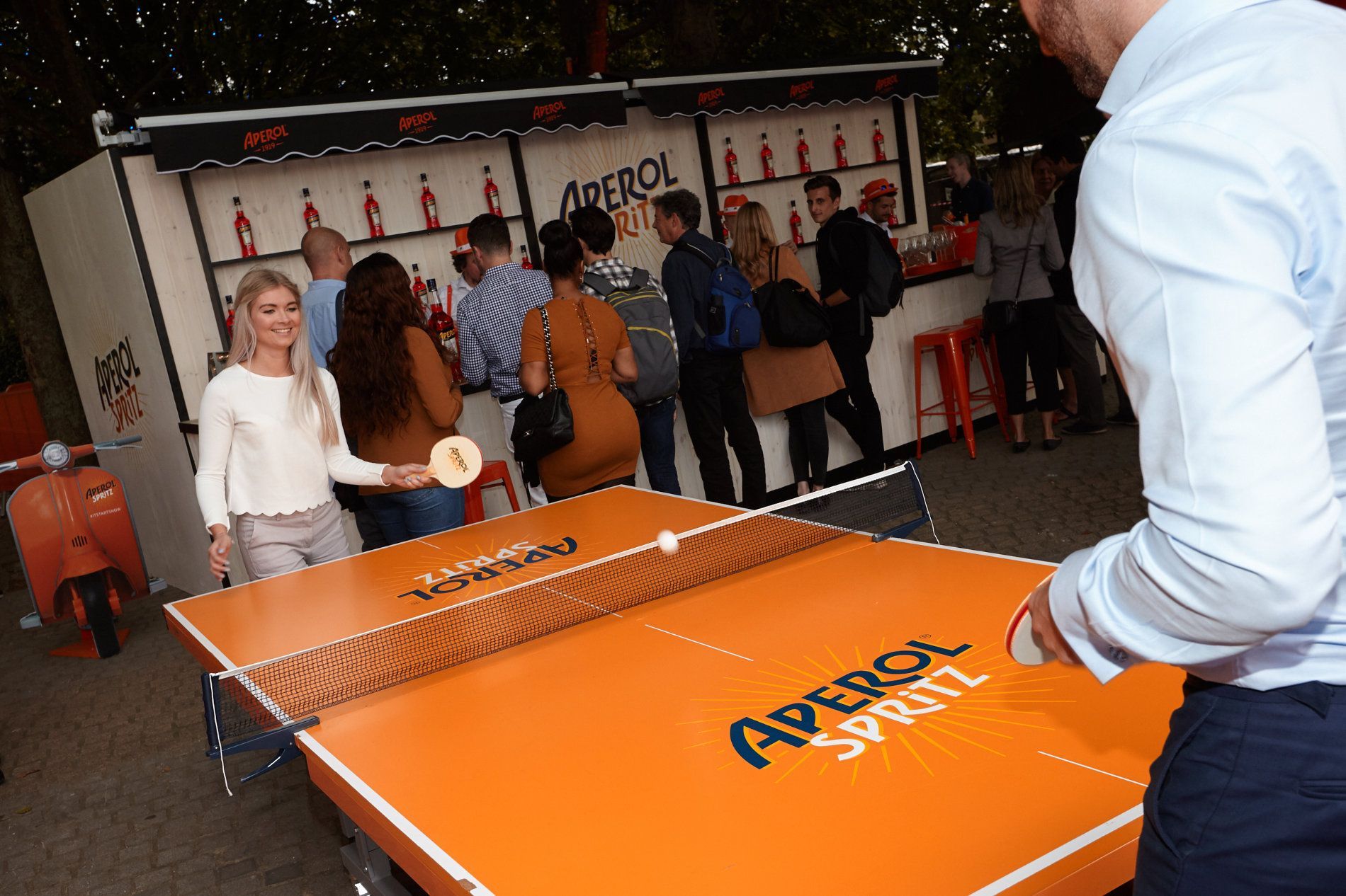 a man is playing ping pong in front of a group of people .