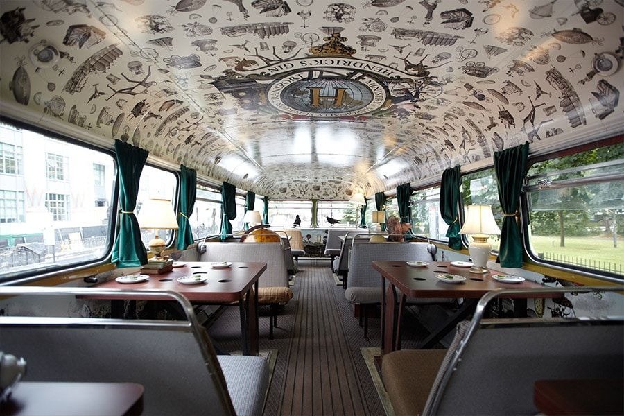 the inside of a restaurant bus with tables and chairs .