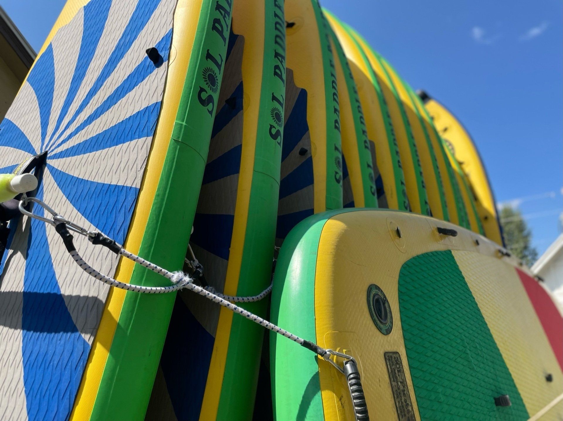 A bunch of surfboards are stacked on top of each other
