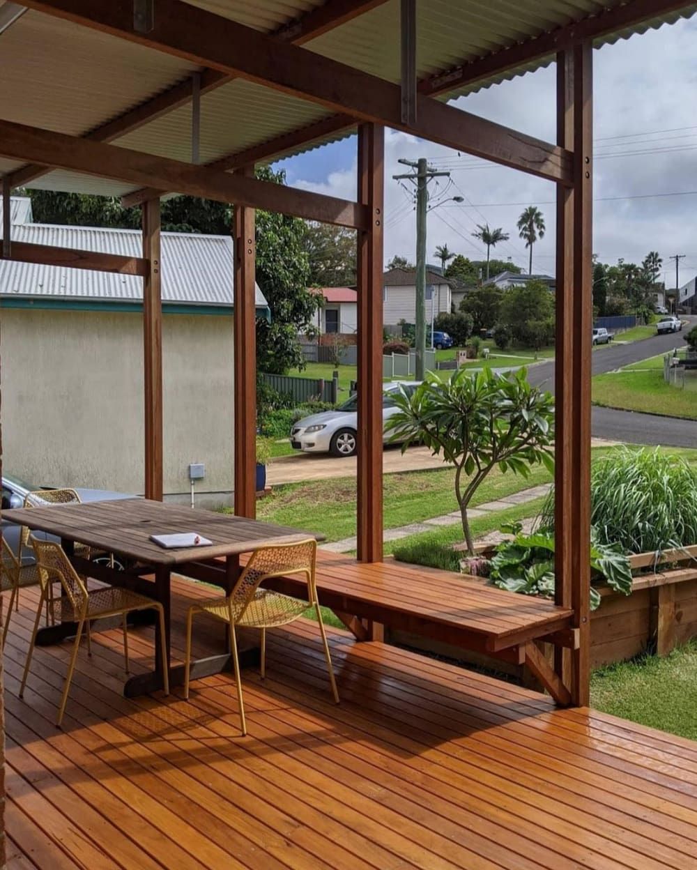 A Wooden Deck With A Table And Chairs On It — Matt Loder Constructions in Bulli, NSW
