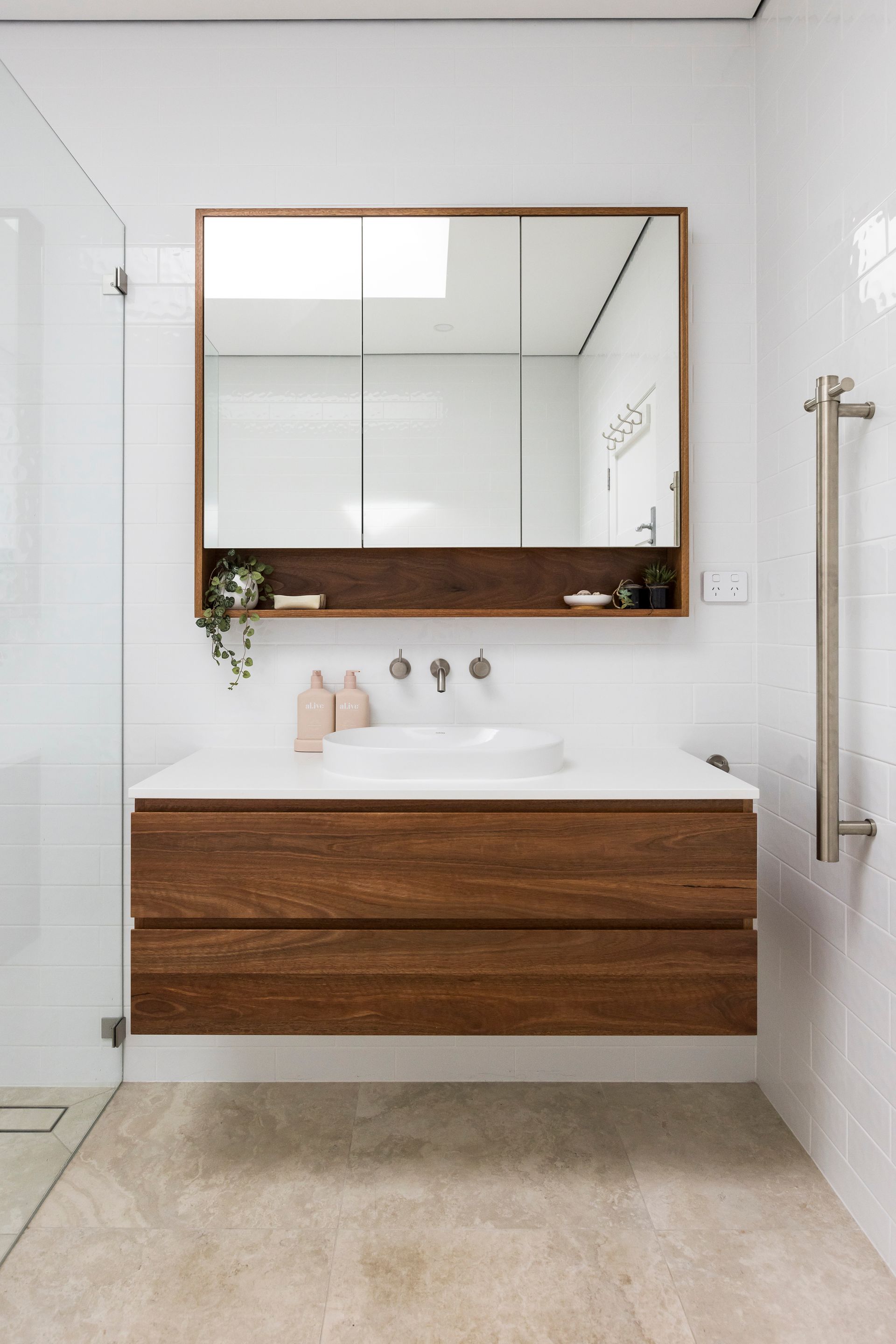 A bathroom with a sink , mirror and walk in shower.  — Matt Loder Constructions in Figtree, NSW
