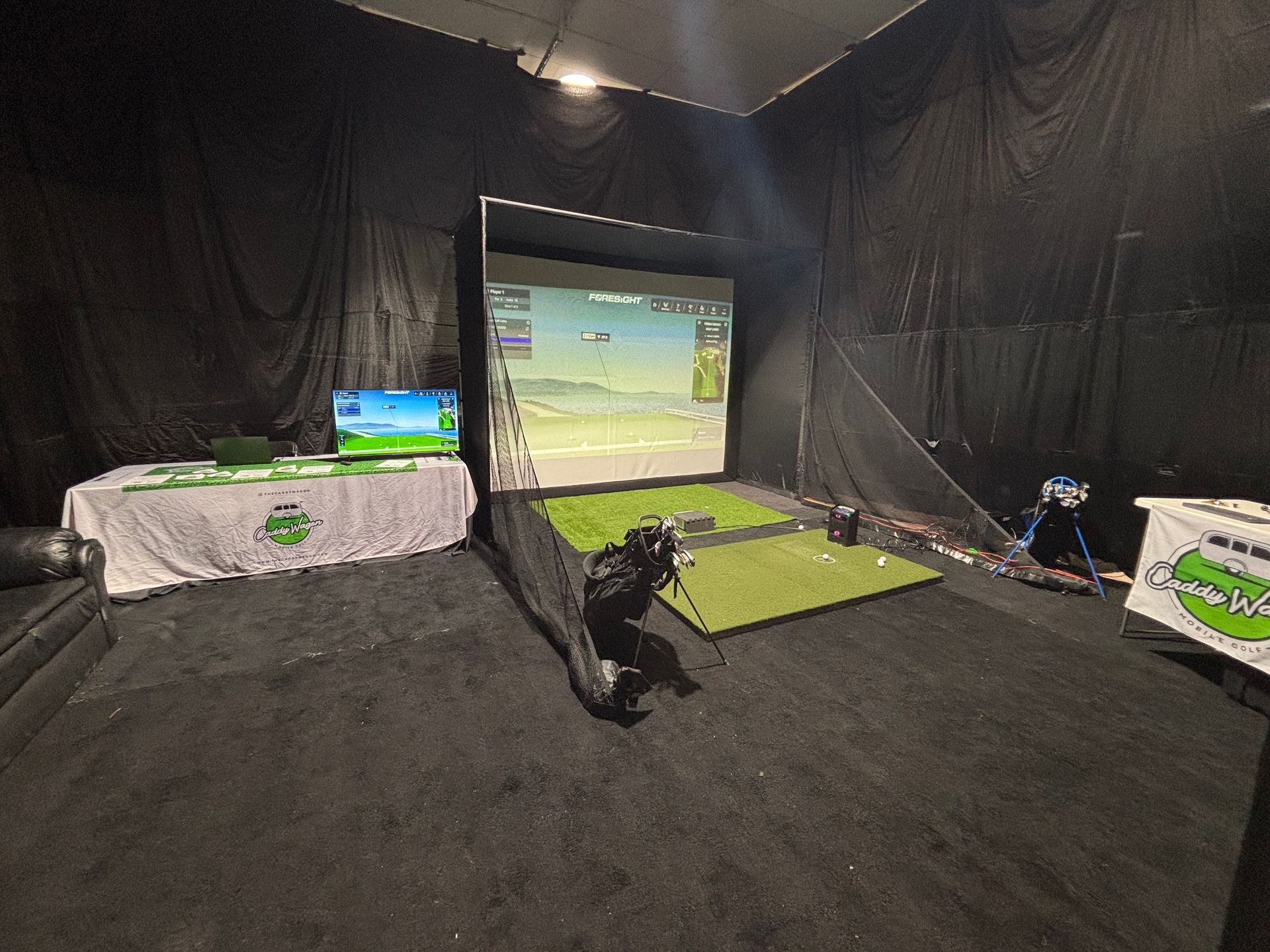 There is a golf simulator in the middle of the room.