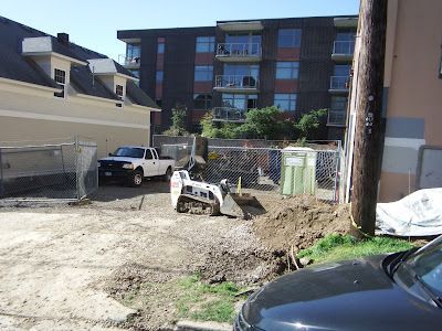 A black car is parked in front of a construction site