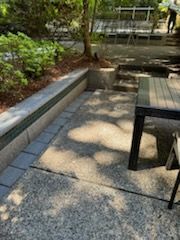 A table and chairs are sitting on a patio in a park.