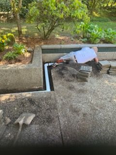 A man is laying on the ground with a shovel.