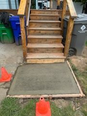 A set of wooden stairs sitting on top of a concrete platform.