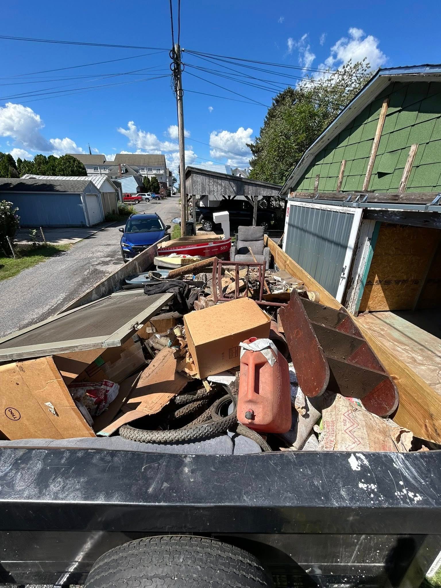 Woman in straw hat smiles, holding wine glass near a lake.