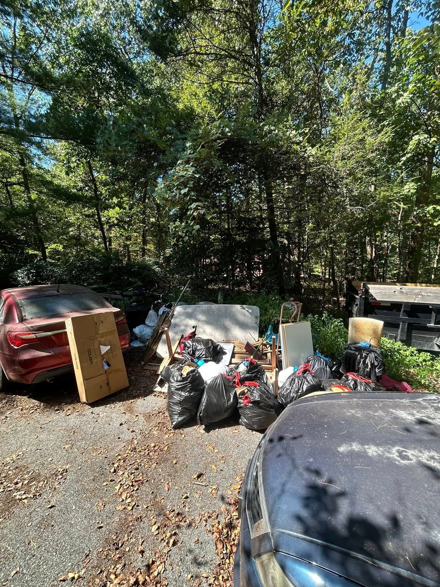 Woman in straw hat smiles, holding wine glass near a lake.