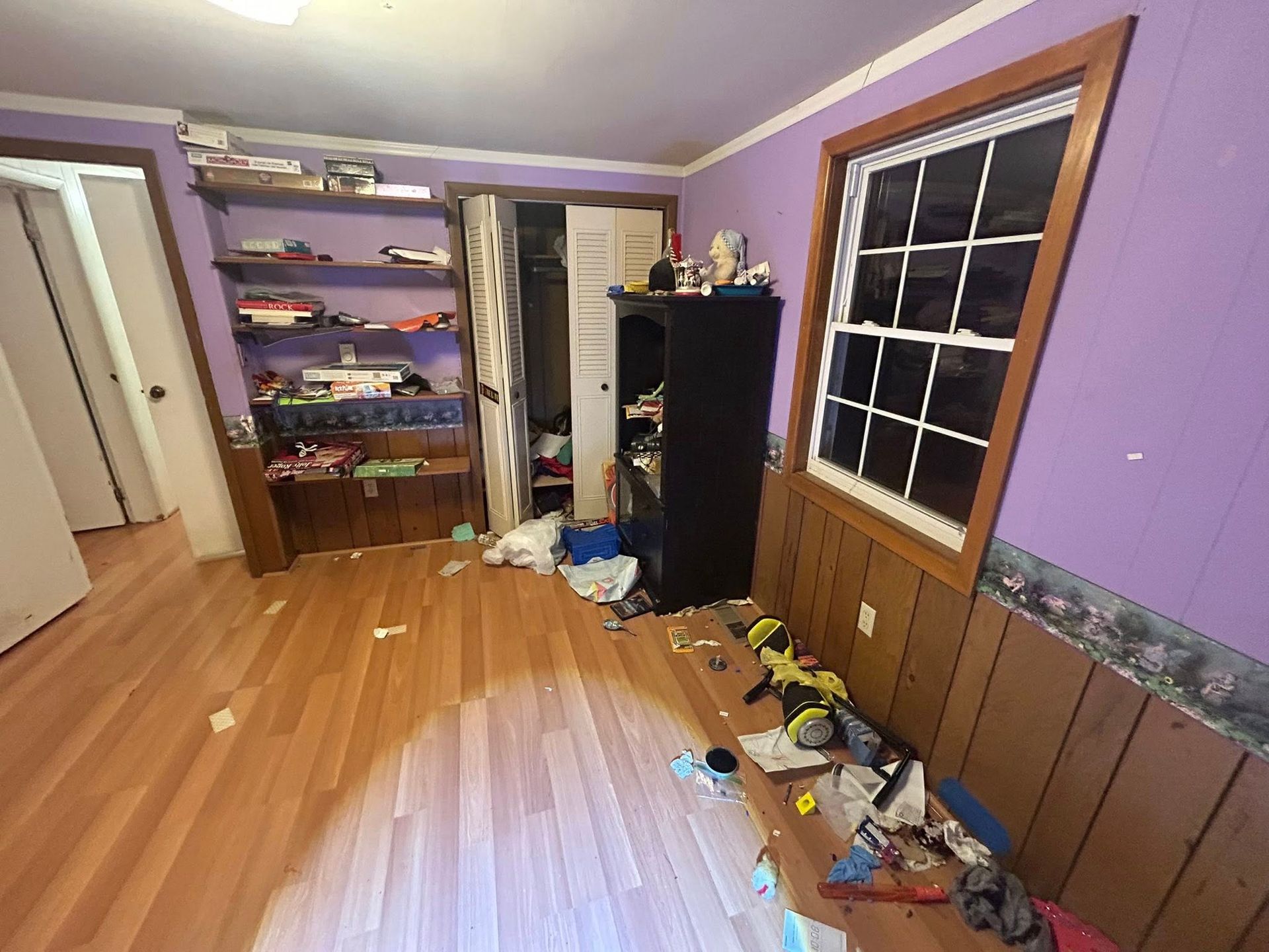Woman in straw hat smiles, holding wine glass near a lake.