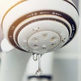 a close up of a shower head with water dripping from it .