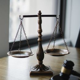 a scale of justice sits on a table next to a gavel