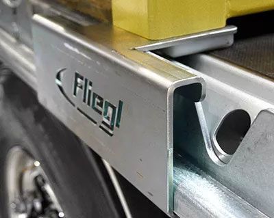 Priekabos konteinerių vežimui su ritinėliais ir rėmais