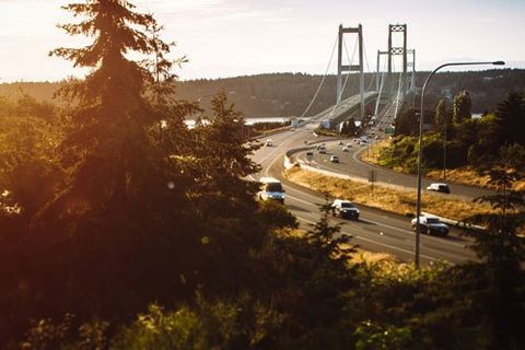 aAn image of cars crossing the Tacoma Narrows Bridge at sunset.  The Tacoma Narrows bridge is actually two twin suspension bridges spanning the Puget Sound, Washington State, USA.  State Route 16 connects to the Kitsap Peninsula and close towns such as Gig Harbor, Port Orchard, and Bremerton.