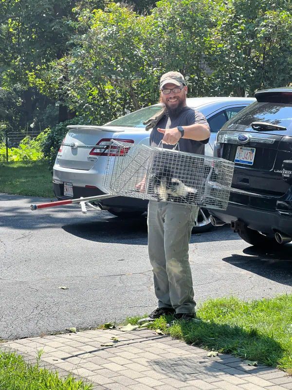 A man is holding a cage with a dog in it.