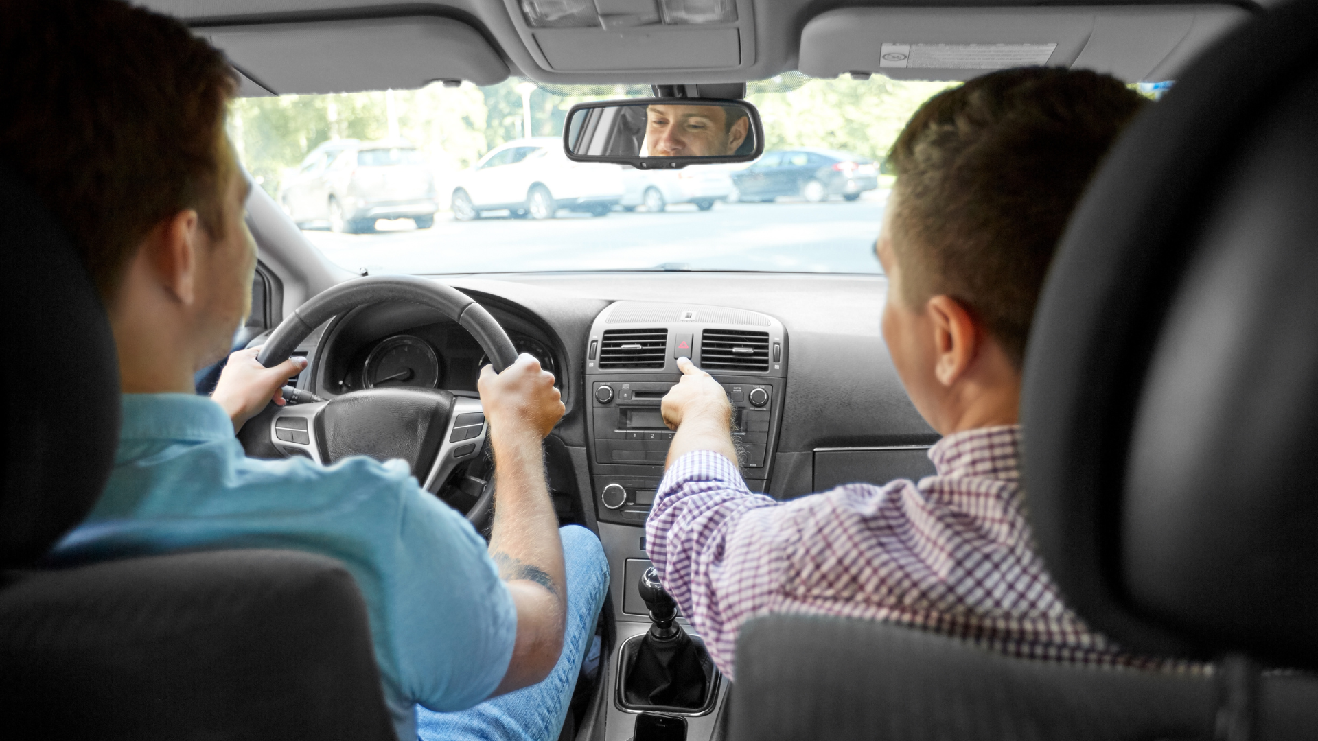 A man is teaching another man how to drive a car.