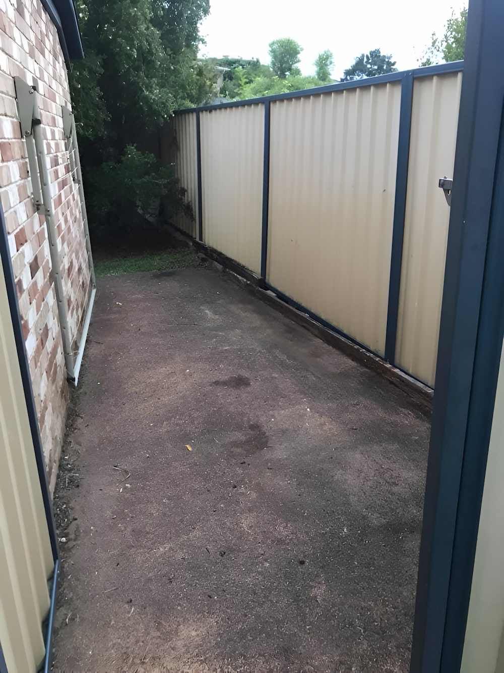 A Brick Building With a Fence Surrounding It — A Load of Rubbish In Coolum, QLD
