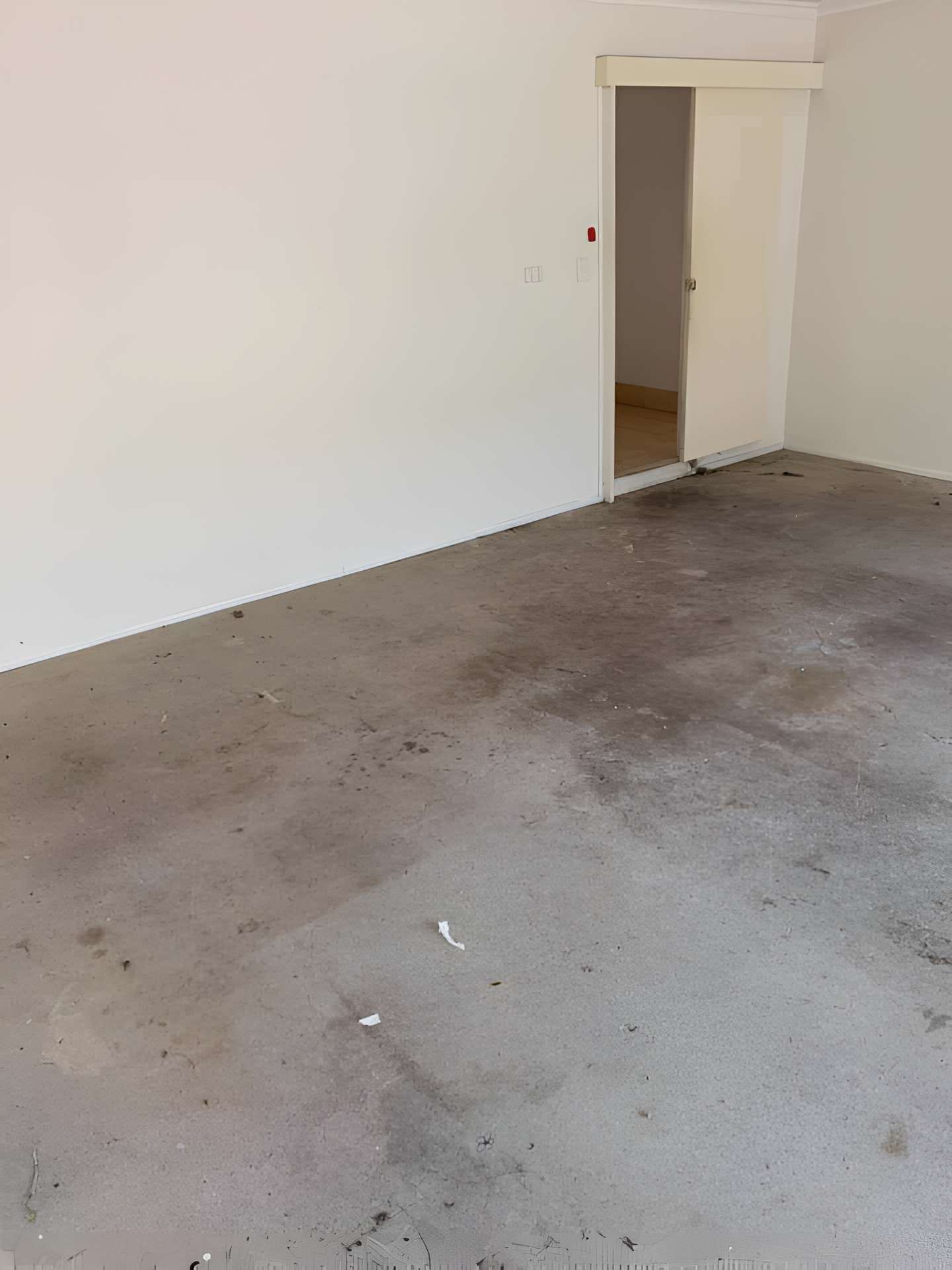 An Empty Room With a Concrete Floor and White Walls — A Load of Rubbish In Maroochydore, QLD