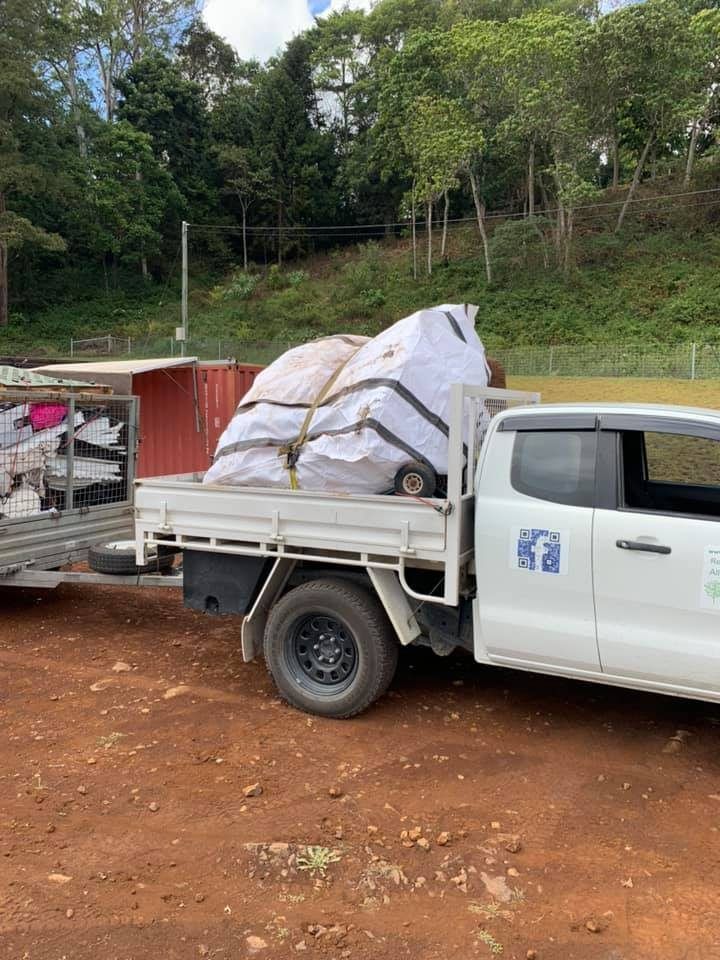 A Pile of Wood is Sitting on Top of a Lush Green Lawn — A Load of Rubbish In Buderim, QLD