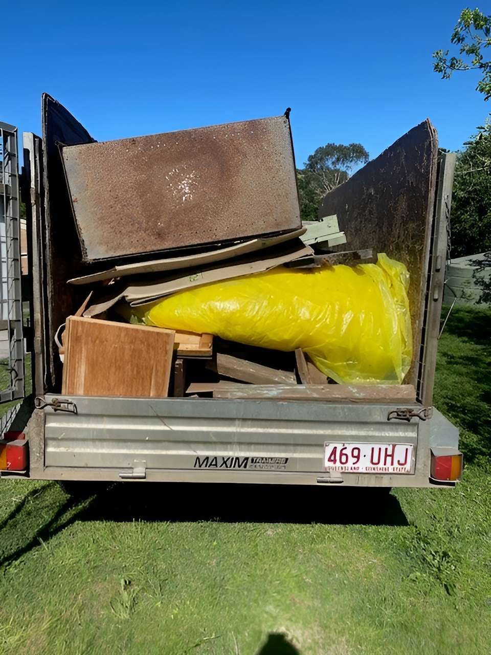The Back of a Trailer Filled With Wood and a Yellow Bag — A Load of Rubbish In Buderim, QLD