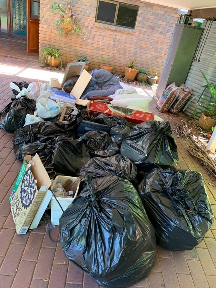 A Pile of Trash Bags Sitting on Top of a Brick Driveway — A Load of Rubbish In Buderim, QLD