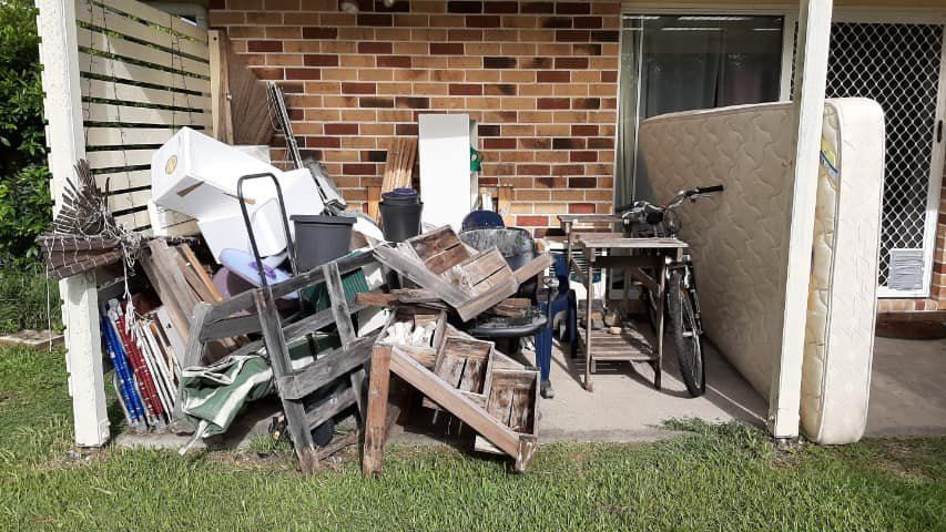 A Pile of Junk is Sitting in Front of a Brick Building — A Load of Rubbish In Buderim, QLD