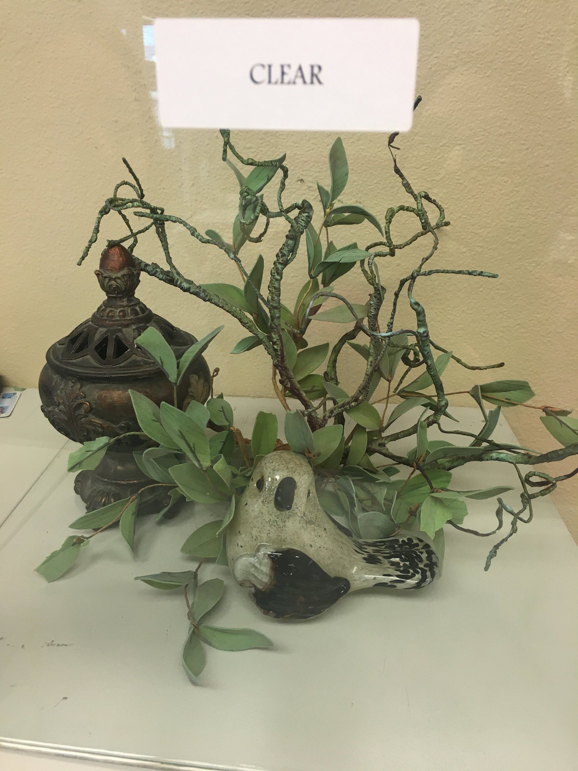 Bird figurine with bronze vessel, faux greenery under 