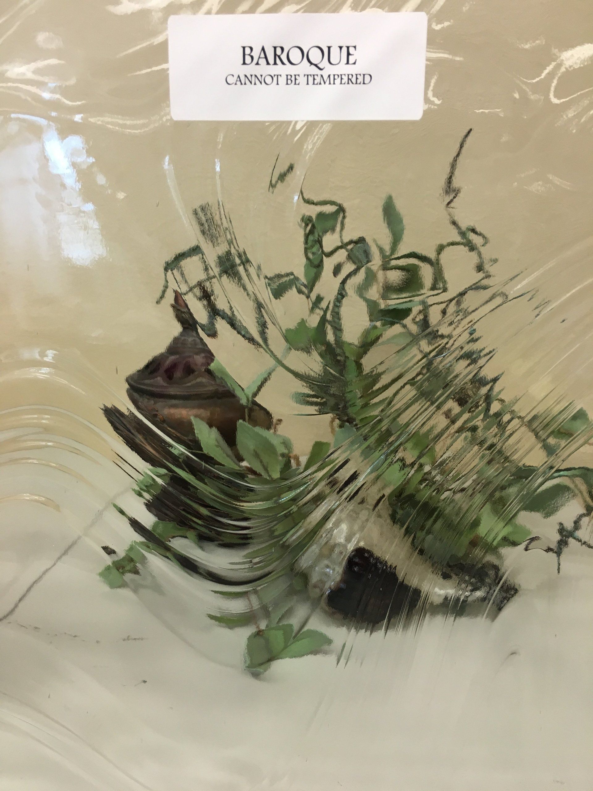 A floral arrangement in a clear container, labeled 