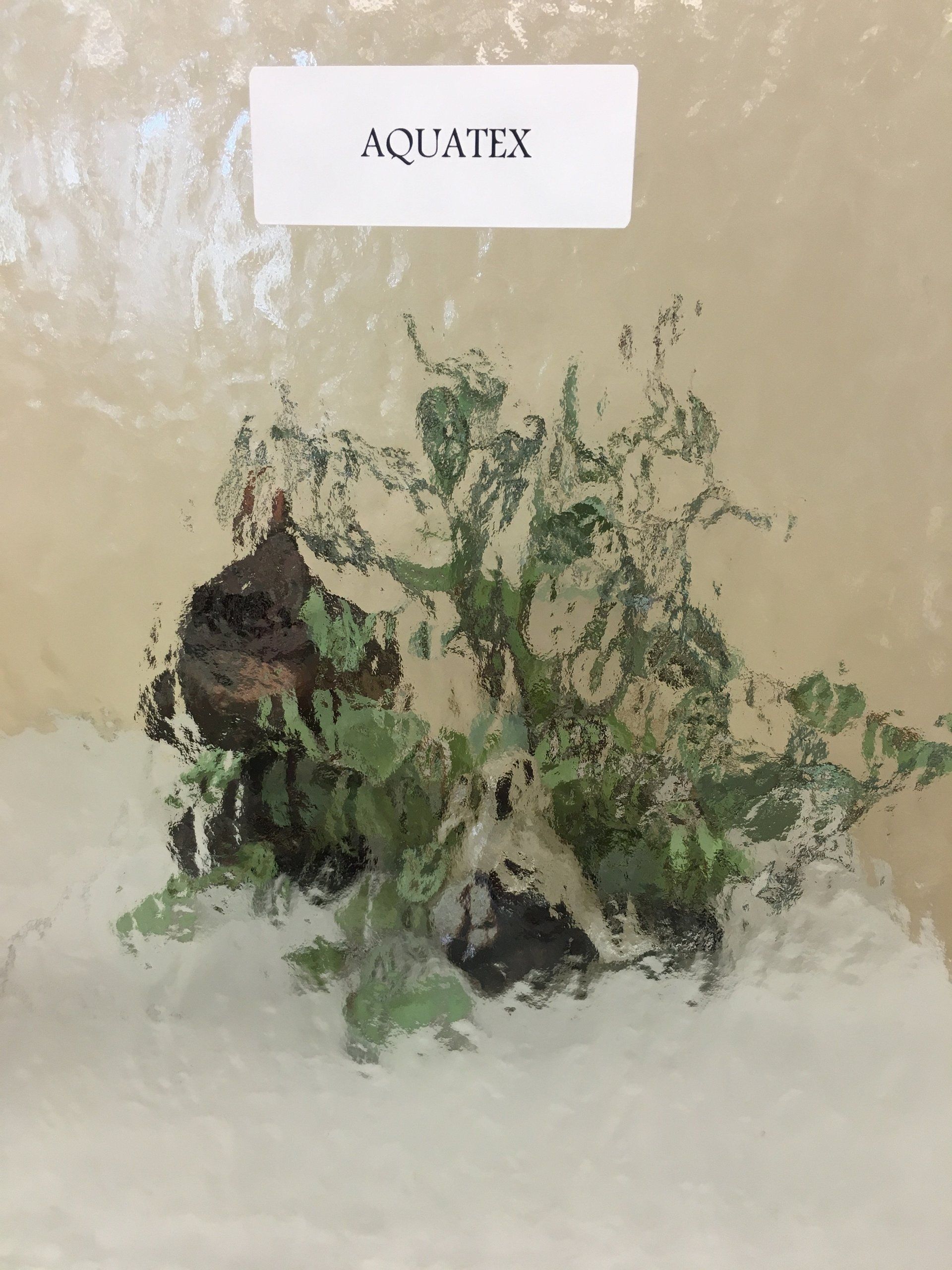 AQUATEX label over a blurred view of aquatic plants and rocks.