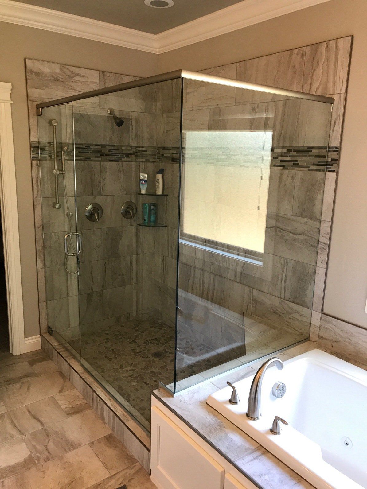 Walk-in shower with glass doors, tile walls, and a built-in bathtub.