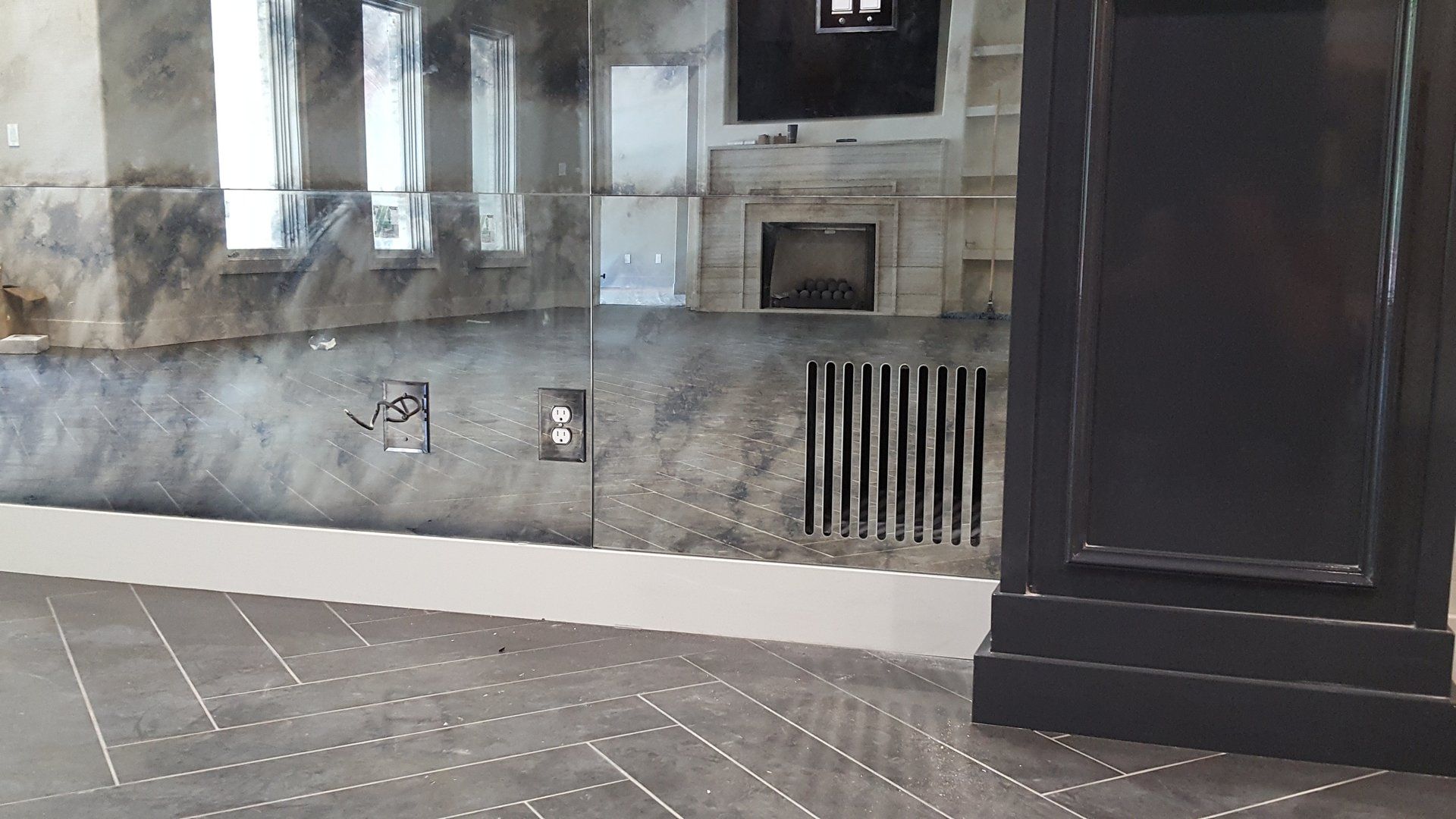 Gray and black tiled room interior with a window and a dark column.