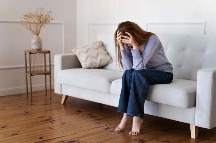a lady with her head in her hands sitting on a couch— Alchemy Wellness Centre In Bangalow, NSW