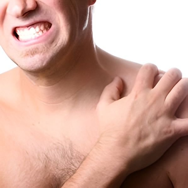 A Shirtless Man Is Holding His Shoulder in Pain — Alchemy Wellness Centre In Bangalow, NSW