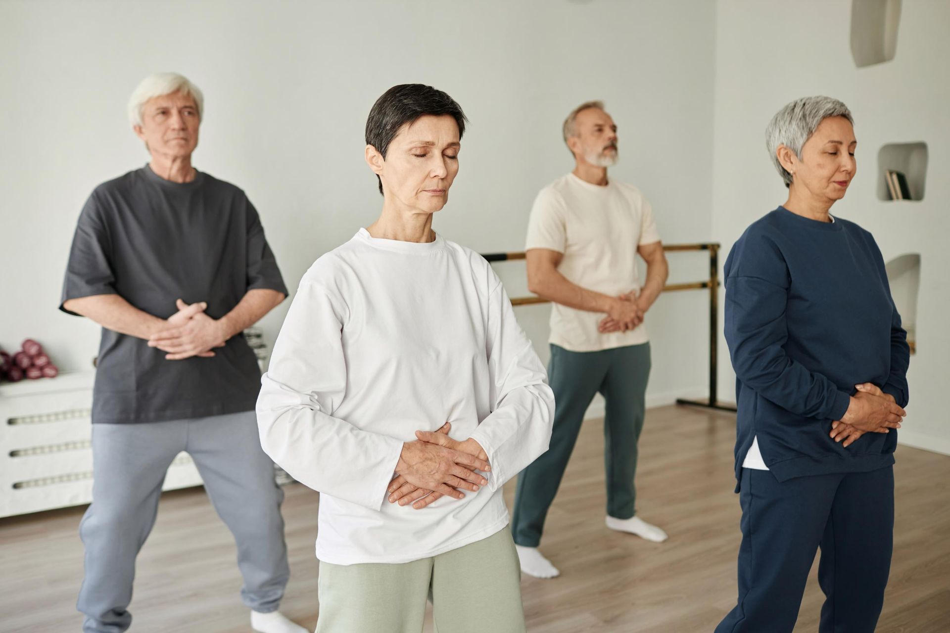A Group of Older People Are Practicing Tai Chi in a Gym — Alchemy Wellness Centre In Bangalow, NSW