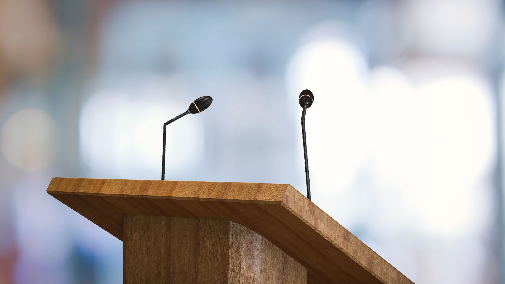 two microphones are sitting on top of a wooden podium .