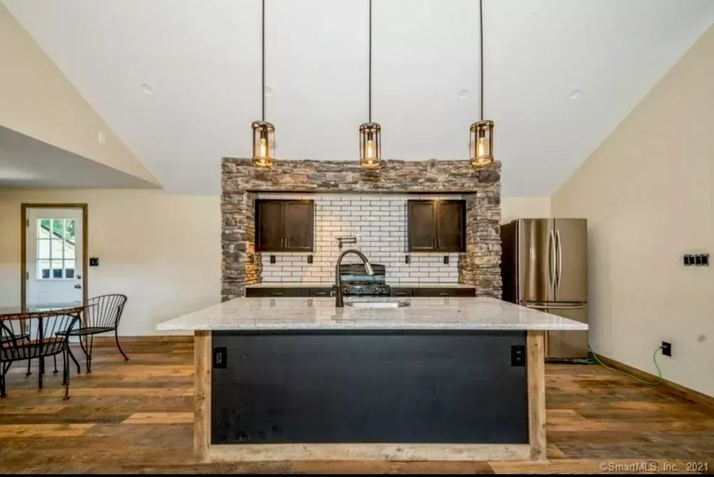 A kitchen with a large island and a refrigerator.