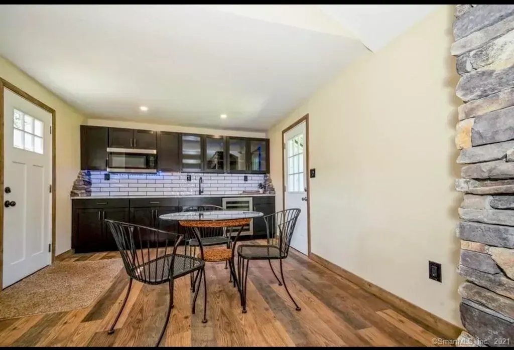 A dining room with a table and chairs next to a kitchen.