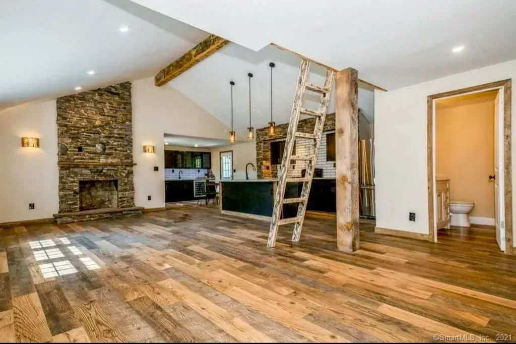 A living room with wooden floors and a ladder in it