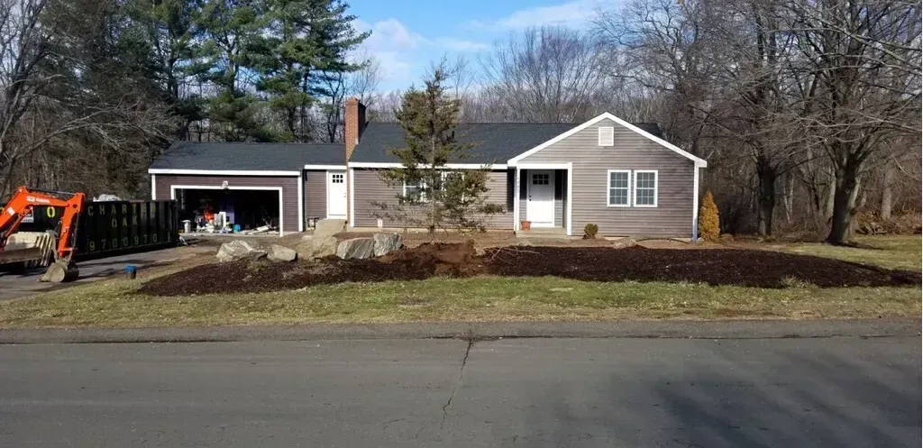A house is sitting on the side of the road next to a road.
